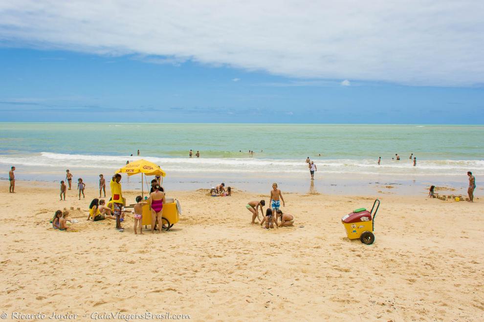 Imagem de crianças brincando na areia da Praia de Curuípe.